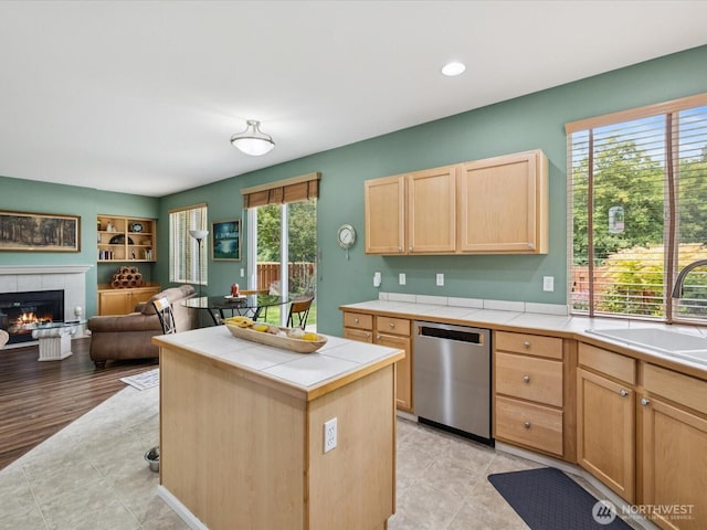 12732 69th Dr SE, Snohomish, WA 98296 - kitchen with stainless steel dishwasher, tile counters, light brown cabinets, a tile fireplace, and open floor plan