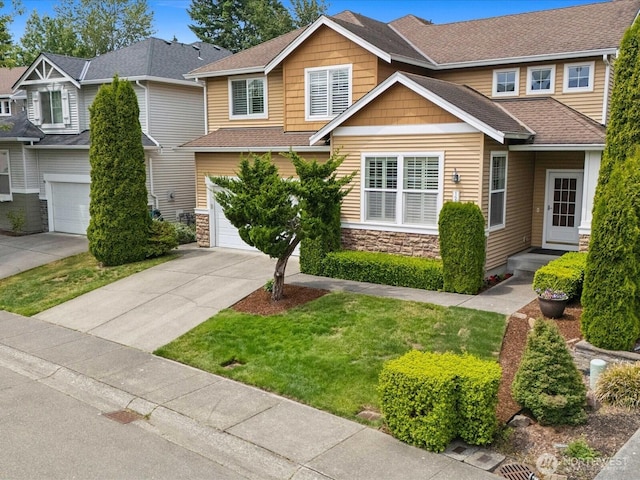 12732 69th Dr SE, Snohomish, WA 98296 - craftsman house featuring a garage, concrete driveway, stone siding, a shingled roof, and a front yard