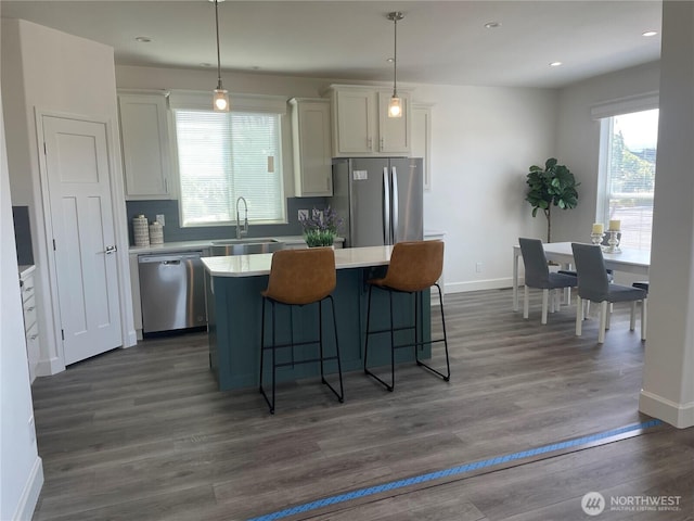 986 N Rock Rose Ave, Sequim, WA 98382 - kitchen with stainless steel appliances, a center island, light countertops, a kitchen bar, and white cabinets