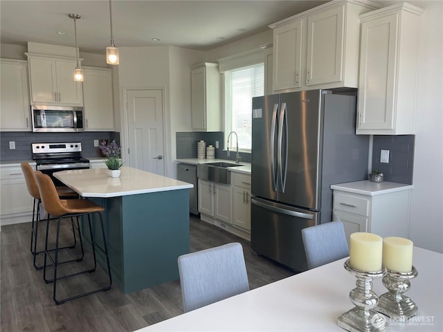 986 N Rock Rose Ave, Sequim, WA 98382 - kitchen featuring stainless steel appliances, tasteful backsplash, dark wood finished floors, a center island, and light countertops
