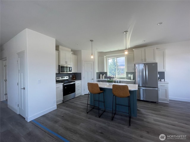 986 N Rock Rose Ave, Sequim, WA 98382 - kitchen featuring stainless steel appliances, white cabinetry, a kitchen island, and dark wood-style floors