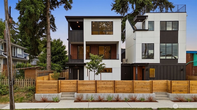 4529 S Orcas St, Seattle, WA 98118 - modern home with a balcony, a fenced front yard, and stucco siding