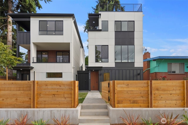 4529 S Orcas St Unit B, Seattle, WA 98118 - modern home with a fenced front yard, a balcony, and stucco siding