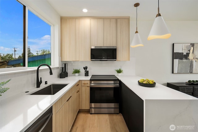 4529 S Orcas St Unit B, Seattle, WA 98118 - kitchen with appliances with stainless steel finishes, light brown cabinets, modern cabinets, light countertops, and a peninsula