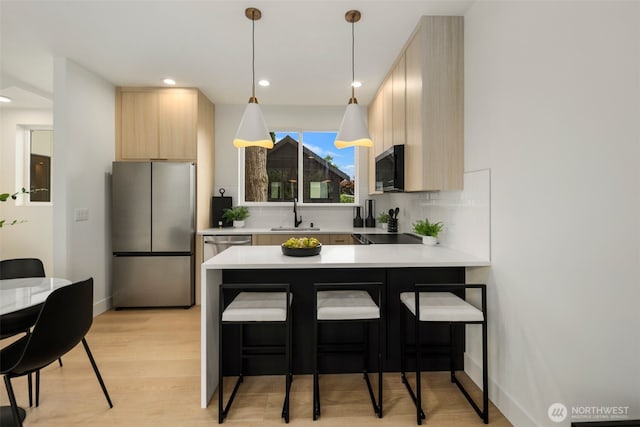 4529 S Orcas St Unit B, Seattle, WA 98118 - kitchen with stainless steel appliances, light brown cabinets, light countertops, a peninsula, and recessed lighting