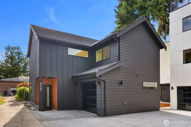 4525 S Orcas St, Seattle, WA 98118 - view of front of house with a garage, board and batten siding, concrete driveway, and roof with shingles