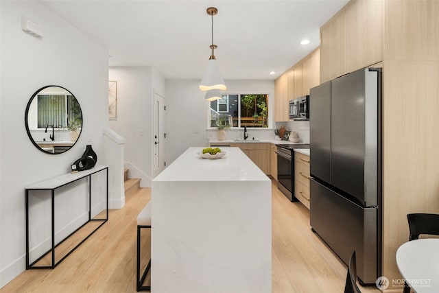 4525 S Orcas St, Seattle, WA 98118 - kitchen with appliances with stainless steel finishes, modern cabinets, light brown cabinets, a kitchen island, and recessed lighting
