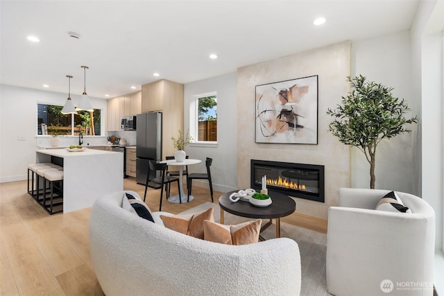 4525 S Orcas St, Seattle, WA 98118 - living area featuring light wood-style floors, healthy amount of natural light, a glass covered fireplace, and recessed lighting