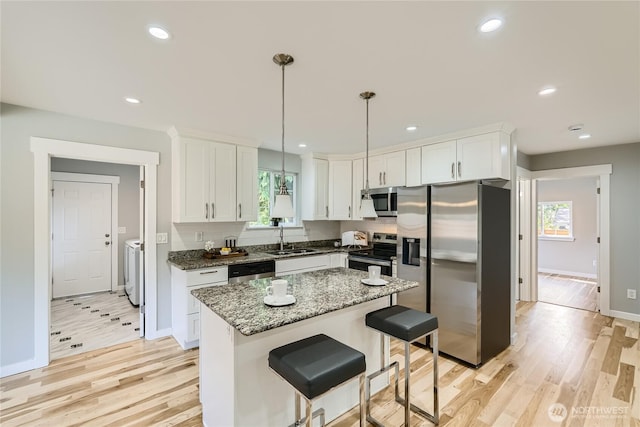 625 SW 122nd St, Seattle, WA 98146 - kitchen featuring appliances with stainless steel finishes, separate washer and dryer, white cabinets, light wood finished floors, and recessed lighting