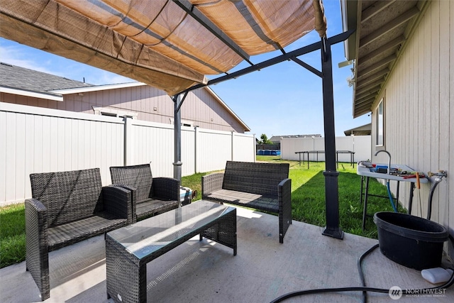 925 S 11th Ave, Othello, WA 99344 - fenced backyard featuring a patio, a trampoline, an outdoor hangout area, and a pergola