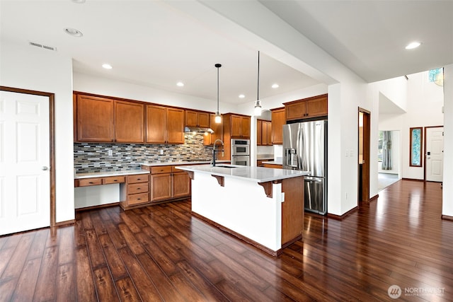 22820 41st Dr SE, Bothell, WA 98021 - kitchen with stainless steel appliances, brown cabinets, light countertops, dark wood-type flooring, and a breakfast bar area
