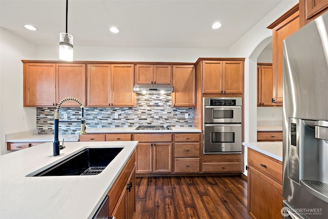 22820 41st Dr SE, Bothell, WA 98021 - kitchen with appliances with stainless steel finishes, under cabinet range hood, light countertops, dark wood finished floors, and brown cabinets