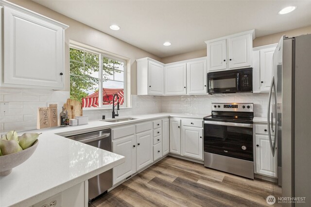 323 Helen St, Sedro Woolley, WA 98284 - kitchen featuring appliances with stainless steel finishes, white cabinets, light countertops, backsplash, and recessed lighting