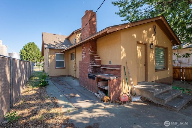 225 Basin St SW, Ephrata, WA 98823 - back of house featuring a chimney, stucco siding, and brick siding