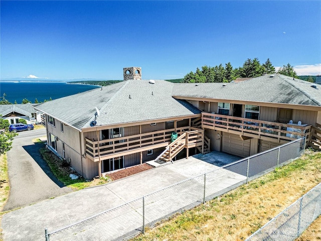 161 Lupine Dr, Sequim, WA 98382 - rear view of house featuring roof with shingles, concrete driveway, a chimney, and a garage