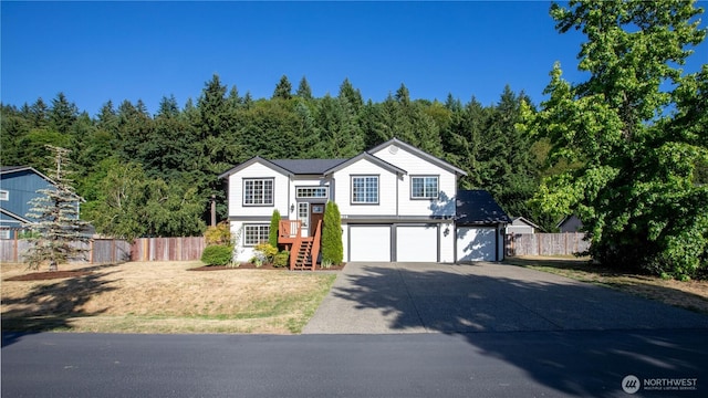 5814 Braywood Ln SE, Olympia, WA 98513 - split foyer home featuring an attached garage, concrete driveway, and a view of trees