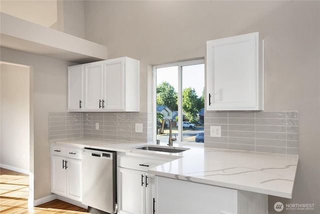 5814 Braywood Ln SE, Olympia, WA 98513 - kitchen featuring stainless steel dishwasher, light stone countertops, white cabinetry, decorative backsplash, and a high ceiling