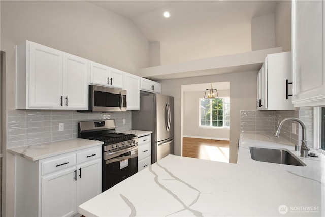 5814 Braywood Ln SE, Olympia, WA 98513 - kitchen with appliances with stainless steel finishes, white cabinetry, light stone counters, backsplash, and decorative light fixtures