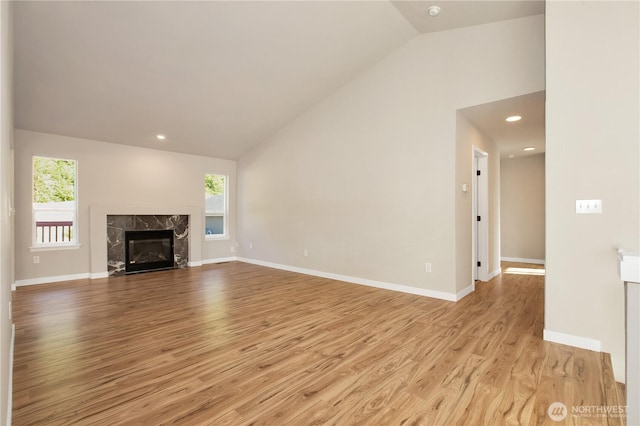 5814 Braywood Ln SE, Olympia, WA 98513 - unfurnished living room with vaulted ceiling, light wood-style floors, plenty of natural light, a high end fireplace, and recessed lighting