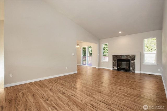 5814 Braywood Ln SE, Olympia, WA 98513 - unfurnished living room with healthy amount of natural light, wood finished floors, vaulted ceiling, a fireplace, and recessed lighting