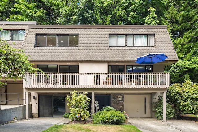16932 NE 2nd Pl, Bellevue, WA 98008 - view of front of house with mansard roof, a shingled roof, a balcony, and stucco siding
