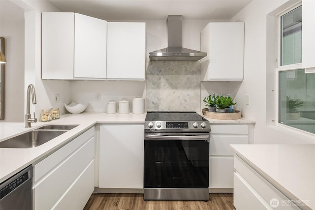 16932 NE 2nd Pl, Bellevue, WA 98008 - kitchen with wall chimney range hood, stainless steel appliances, light countertops, and white cabinets