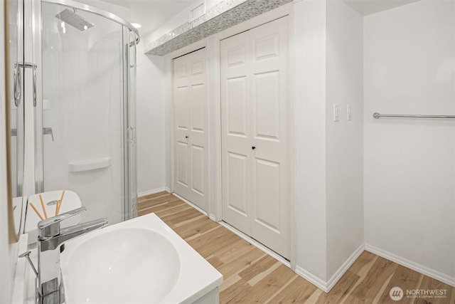 16932 NE 2nd Pl, Bellevue, WA 98008 - bathroom featuring wood finished floors, a shower stall, and a closet
