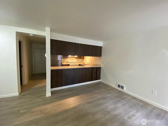 1750 NW 58th St, Seattle, WA 09107 - kitchen with freestanding refrigerator, light countertops, dark wood-style flooring, dark brown cabinets, and electric range