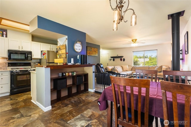 1390 Jordan Ct, Oak Harbor, WA 98277 - dining room featuring stone finish flooring, ceiling fan, and a chandelier