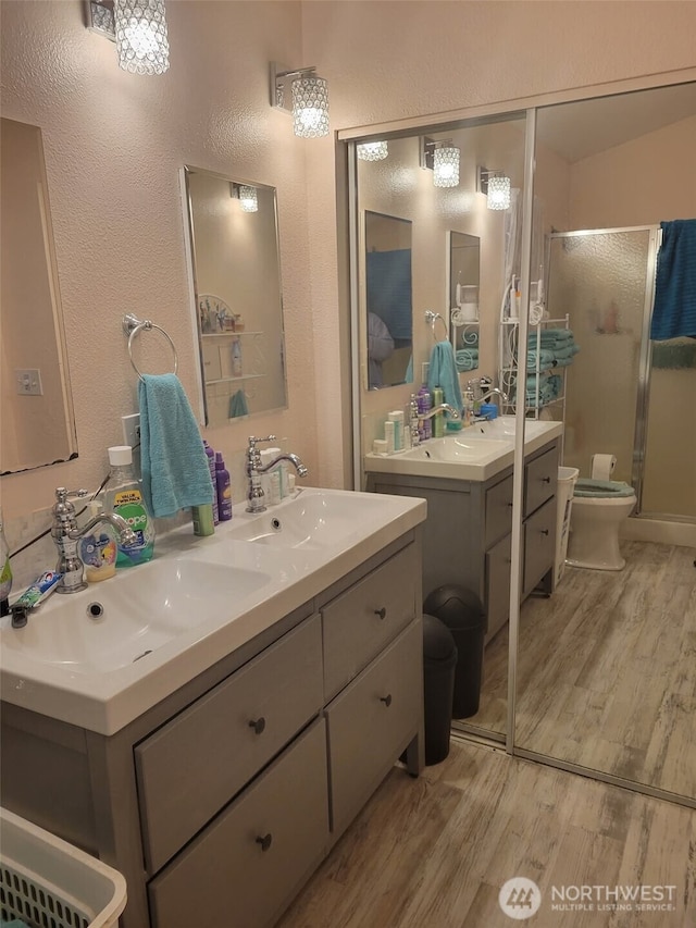 118 Ocean Lake Way NE, Ocean Shores, WA 98569 - bathroom featuring wood finished floors, double vanity, a stall shower, and a textured wall
