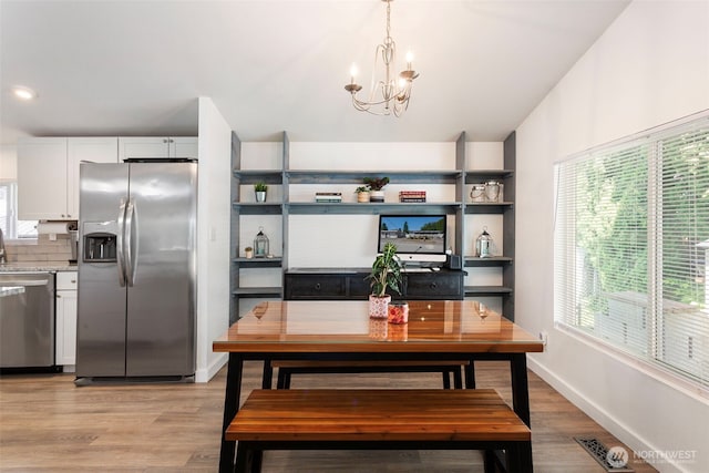 207 6th St, Sultan, WA 98294 - dining area with a chandelier, plenty of natural light, and light wood-style floors