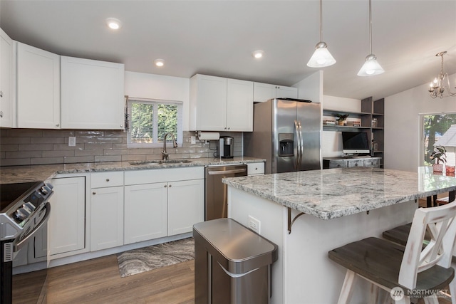 207 6th St, Sultan, WA 98294 - kitchen with appliances with stainless steel finishes, a breakfast bar area, tasteful backsplash, white cabinetry, and recessed lighting