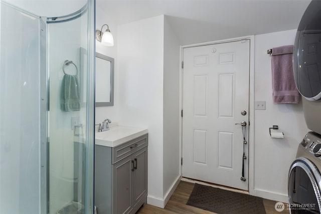 207 6th St, Sultan, WA 98294 - full bath with stacked washer and clothes dryer, a stall shower, wood finished floors, and vanity