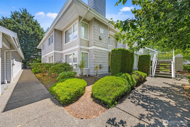 11130 SE 208th St Unit N101, Kent, WA 98031 - view of home's exterior with stairway and a chimney