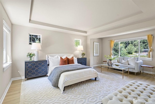 2648 116th Ave NE, Bellevue, WA 98004 - bedroom featuring a raised ceiling, light wood-style flooring, and multiple windows