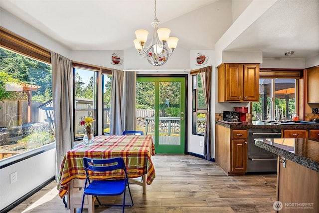 9304 Farwest Dr SW, Tacoma, WA 98498 - kitchen with dishwashing machine, a chandelier, brown cabinets, healthy amount of natural light, and vaulted ceiling