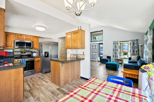 9304 Farwest Dr SW, Tacoma, WA 98498 - kitchen featuring stainless steel appliances, open floor plan, vaulted ceiling, light wood finished floors, and a peninsula