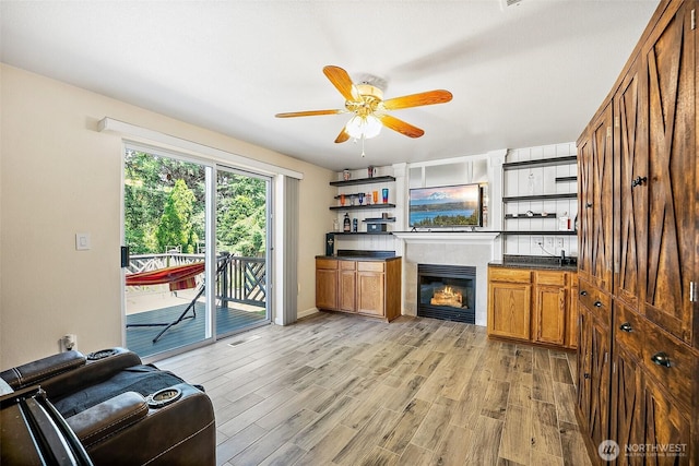 9304 Farwest Dr SW, Tacoma, WA 98498 - living area featuring light wood-style floors, ceiling fan, and a glass covered fireplace