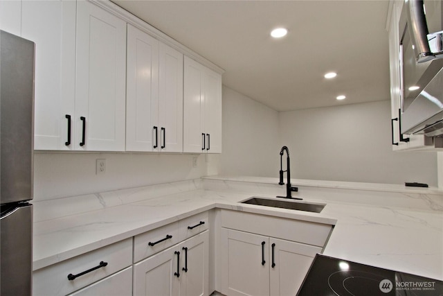 11811 93rd Ln NE Unit 102, Kirkland, WA 98034 - kitchen featuring freestanding refrigerator, recessed lighting, white cabinetry, black electric stovetop, and light stone counters