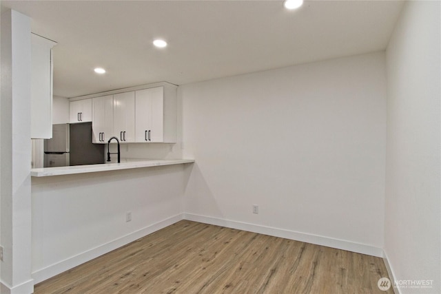 11811 93rd Ln NE Unit 102, Kirkland, WA 98034 - kitchen featuring freestanding refrigerator, light wood-type flooring, recessed lighting, white cabinets, and light countertops