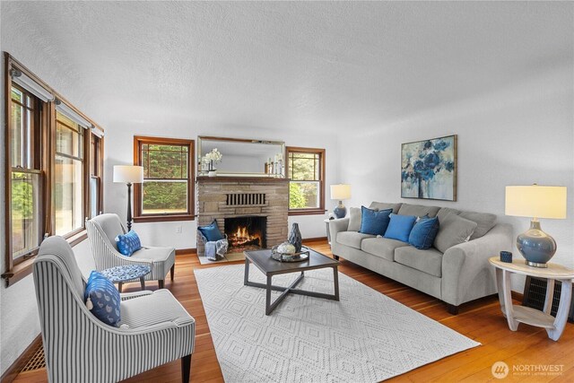 34226 42nd Ave S, Auburn, WA 98001 - living area with a warm lit fireplace, wood finished floors, and a textured ceiling