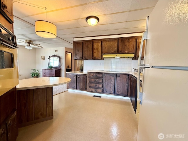 1519 Alonda Ln NE, Olympia, WA 98516 - kitchen featuring freestanding refrigerator, wall oven, light countertops, dark brown cabinetry, and ceiling fan
