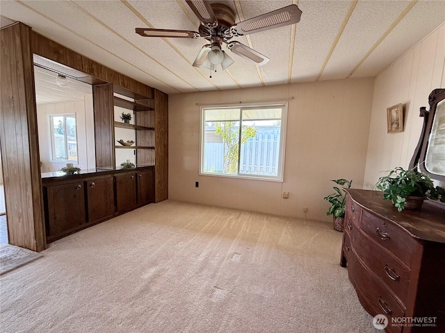 1519 Alonda Ln NE, Olympia, WA 98516 - living area with light colored carpet, wooden walls, ceiling fan, and a textured ceiling