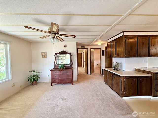 1519 Alonda Ln NE, Olympia, WA 98516 - kitchen featuring dark brown cabinets, light colored carpet, a textured ceiling, light countertops, and a ceiling fan