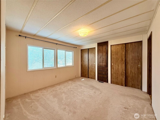 1519 Alonda Ln NE, Olympia, WA 98516 - unfurnished bedroom featuring carpet floors, two closets, and a textured ceiling