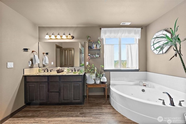 16908 61st St NW, Vaughn, WA 98394 - bathroom featuring double vanity, a jetted tub, and wood finished floors