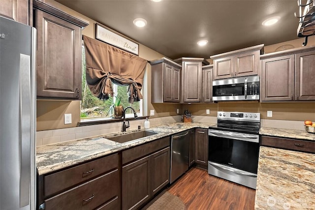 16908 61st St NW, Vaughn, WA 98394 - kitchen with appliances with stainless steel finishes, dark wood-type flooring, light stone countertops, dark brown cabinetry, and recessed lighting