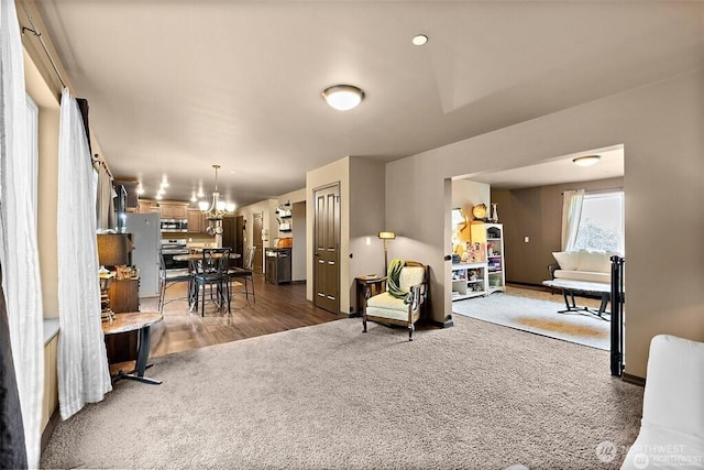 16908 61st St NW, Vaughn, WA 98394 - carpeted living room featuring wood finished floors and a chandelier