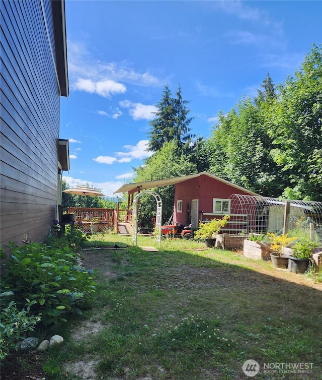 16908 61st St NW, Vaughn, WA 98394 - view of green lawn featuring a garden, a deck, and an outdoor structure