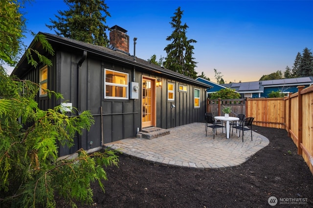 3130 SW 97th St, Seattle, WA 98126 - back of house featuring board and batten siding, a chimney, a patio area, and a fenced backyard